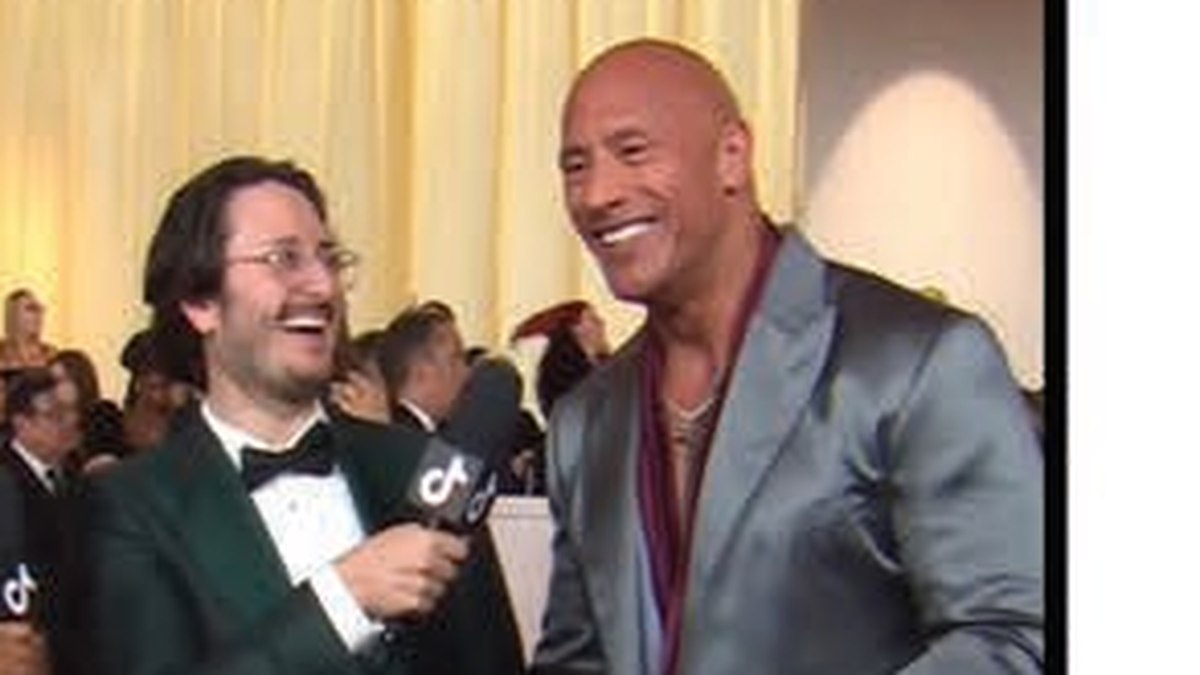 A TikTok host interviewing a guest on the Oscars red carpet